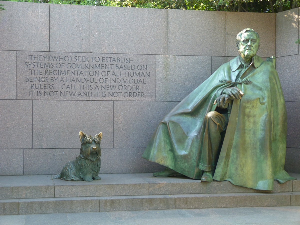 Franklin Delano Roosevelt Memorial, Washington, D.C., 2016 Statue of a seated man wearing a cape next to statue of a Scottie dog, mounted on granite with a granite wall with inscribed text behind them