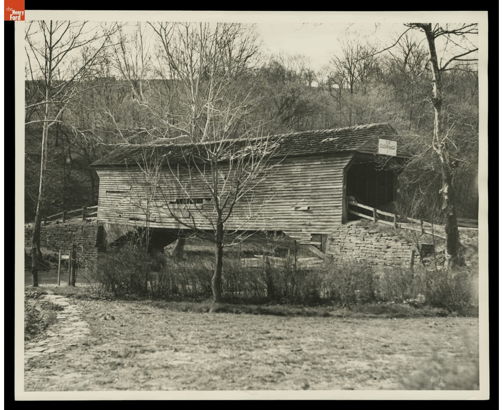 GIF slowly cycling through three views of a wooden covered bridge in some disrepair