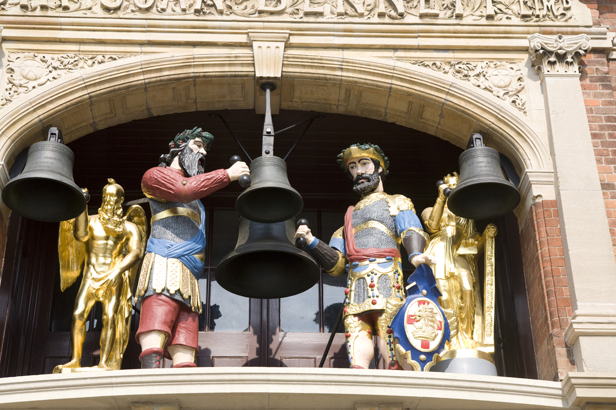 Two painted and two gilt figures among four bells