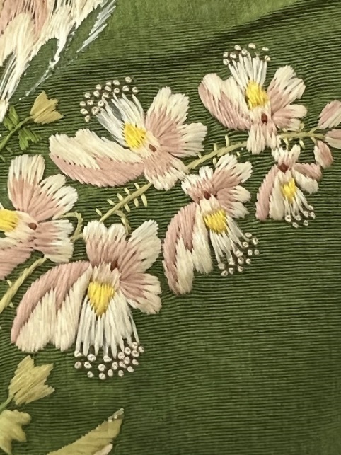 Moss-green fabric with floral embroidery in pinks and yellow