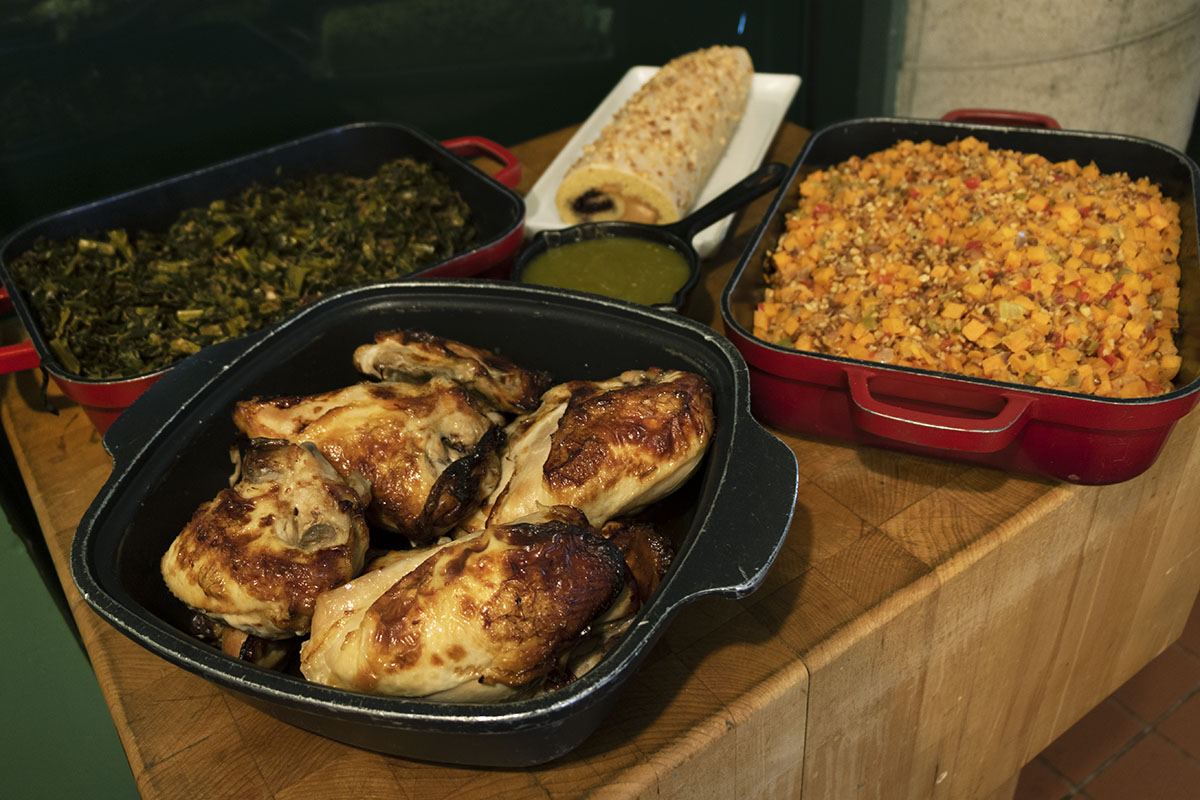 Spring offerings from George Washington Carver's recipes at A Taste of History Dishes containing chicken, greens, mixed vegetables, a green sauce, and a rolled cake