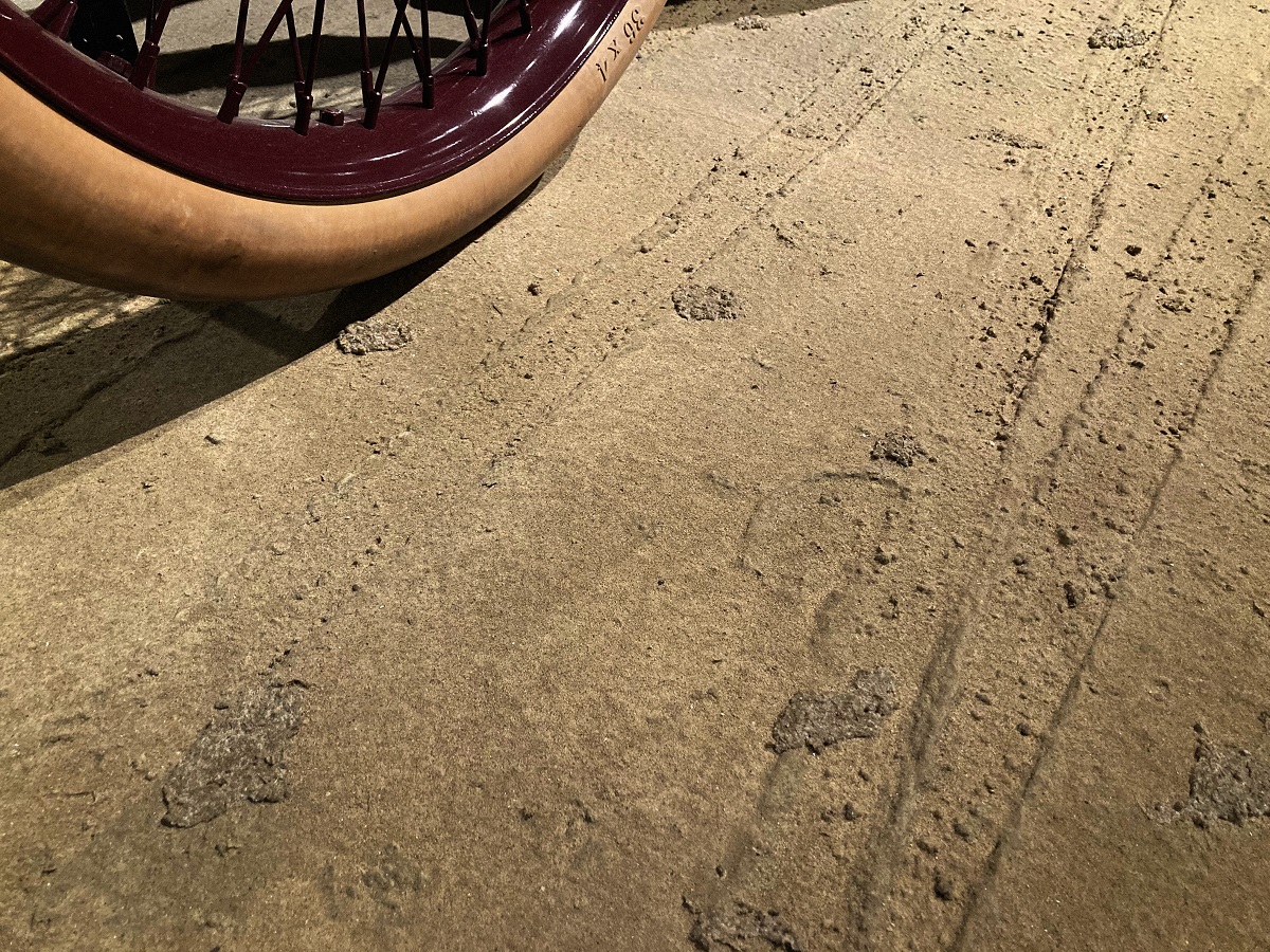 Faux dirt surface under Sweepstakes wheel Dirt-looking surface with tire tracks and hoofprints built in; part of tire visible in corner of photo