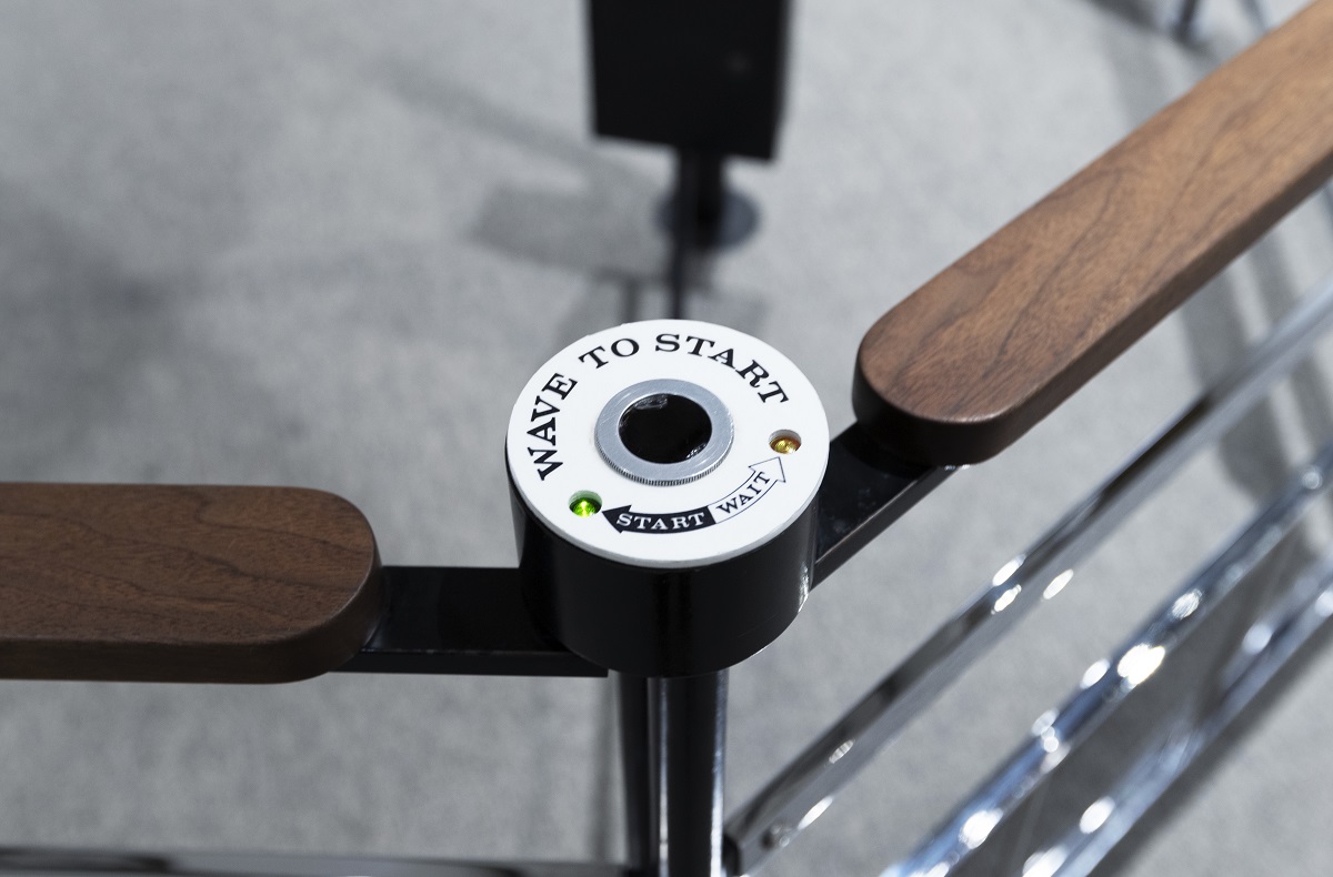 Metal and wood railing with a white sensor mounted on it, with text reading 