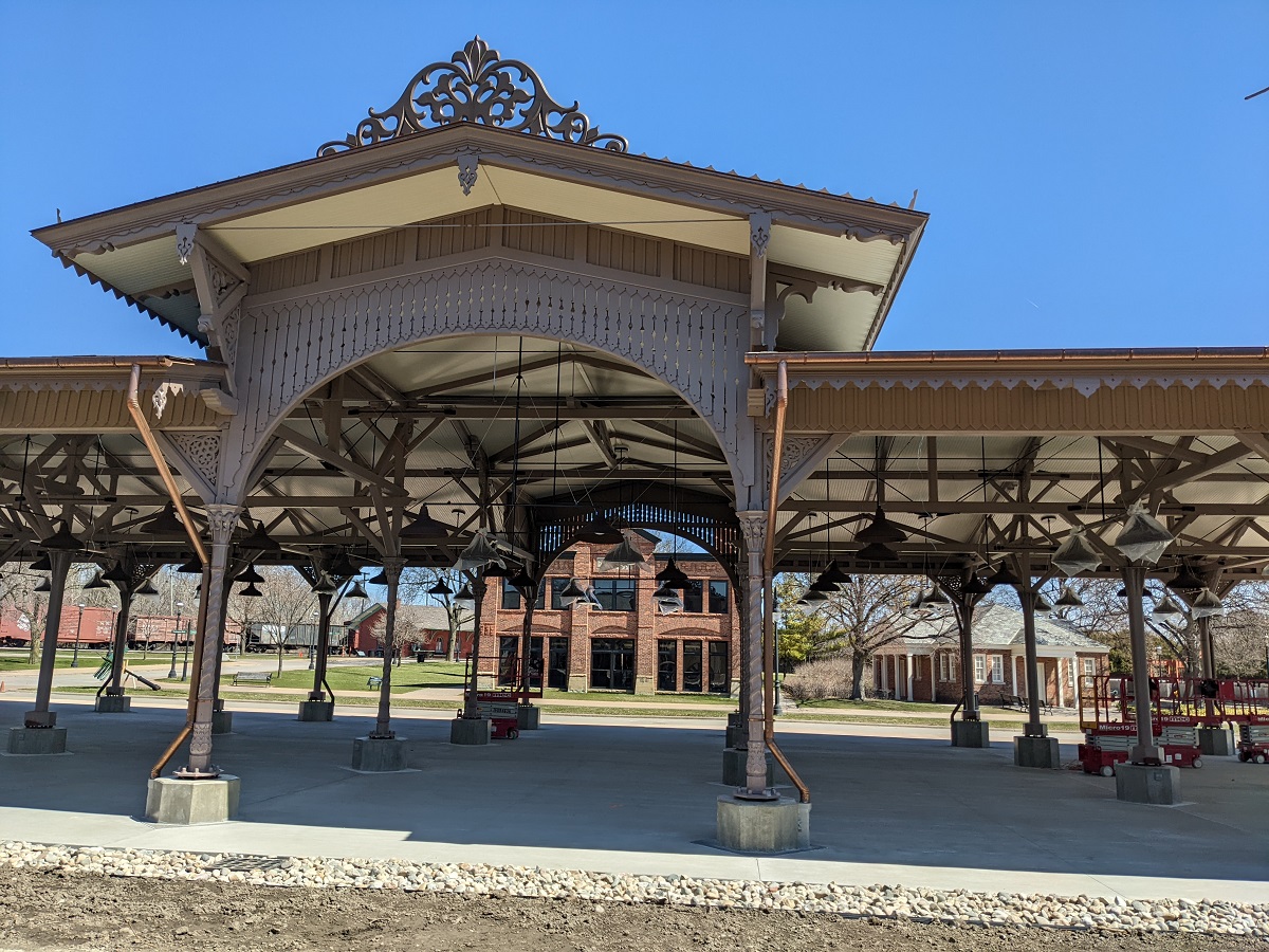 Detail of open-sided building with many support columns and decorative elements around roof