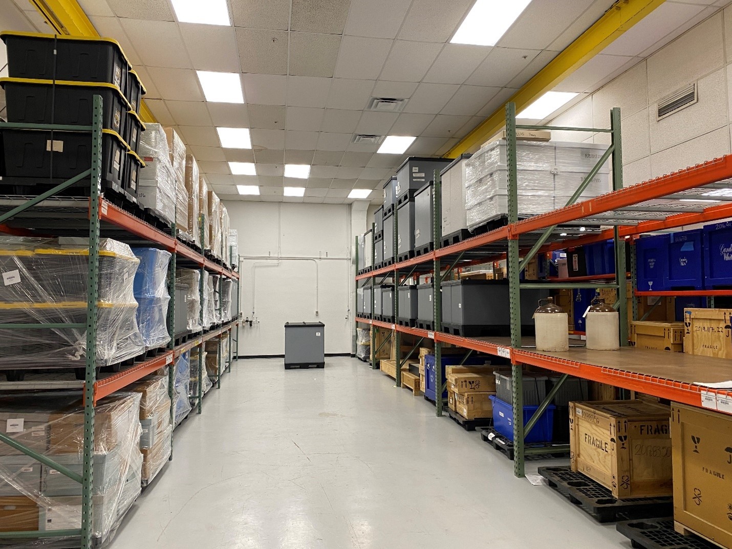 Pallet racking and thoughtfully packed artifacts Shelving holds many boxes, crates, and shrink-wrapped pallets
