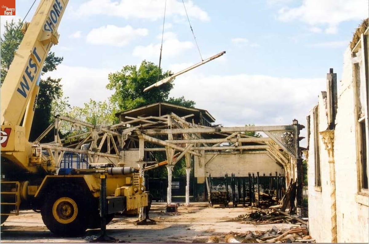 Crane removing large beam from largely dismantled structure
