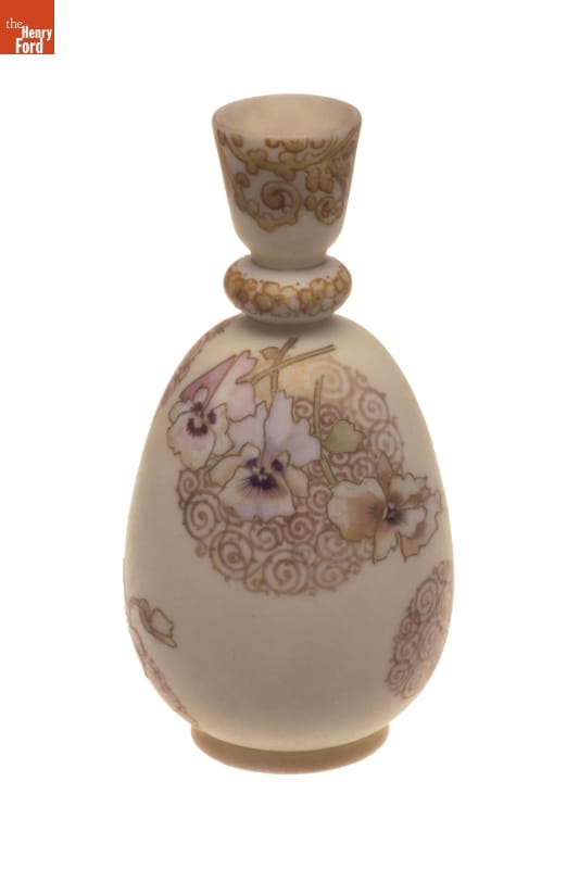 Beige vase with intricate top and pattern of pansies and swirls