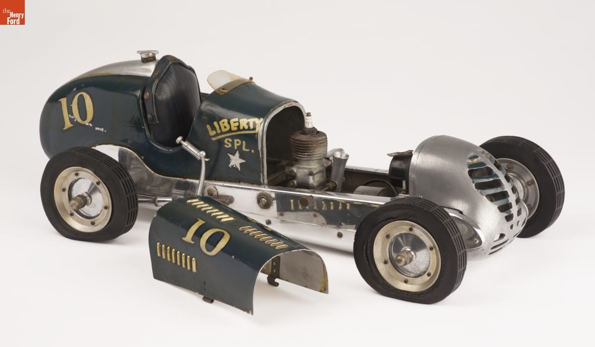 Korn Long green model car with text and numbers on side, hood removed and sitting next to car