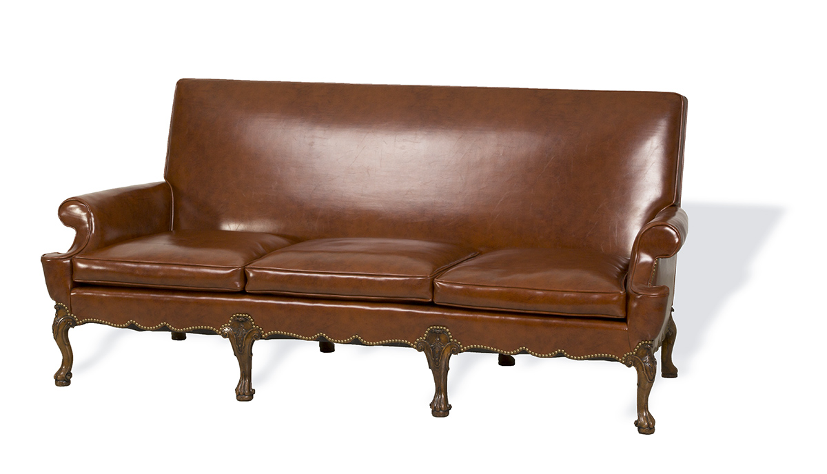 Brown leather sofa with decorative wooden legs