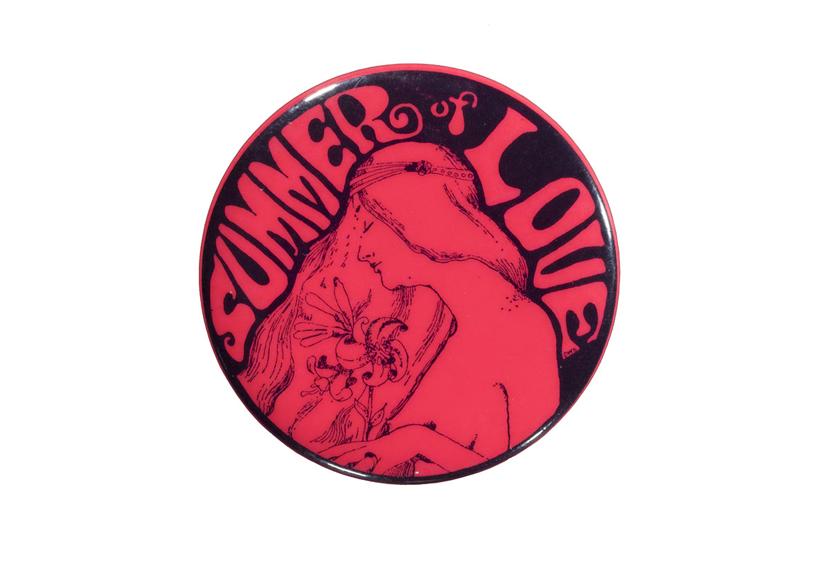 Bright pink button with image of long-haired woman holding flowers and text 