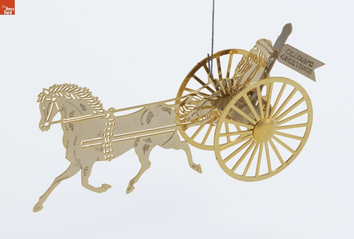 Gold and white metal ornament depicting Santa and a flag reading 
