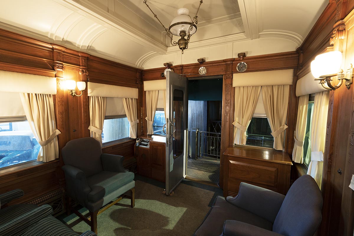 Room interior with arched ceiling, blue upholstered furniture, and wood paneling