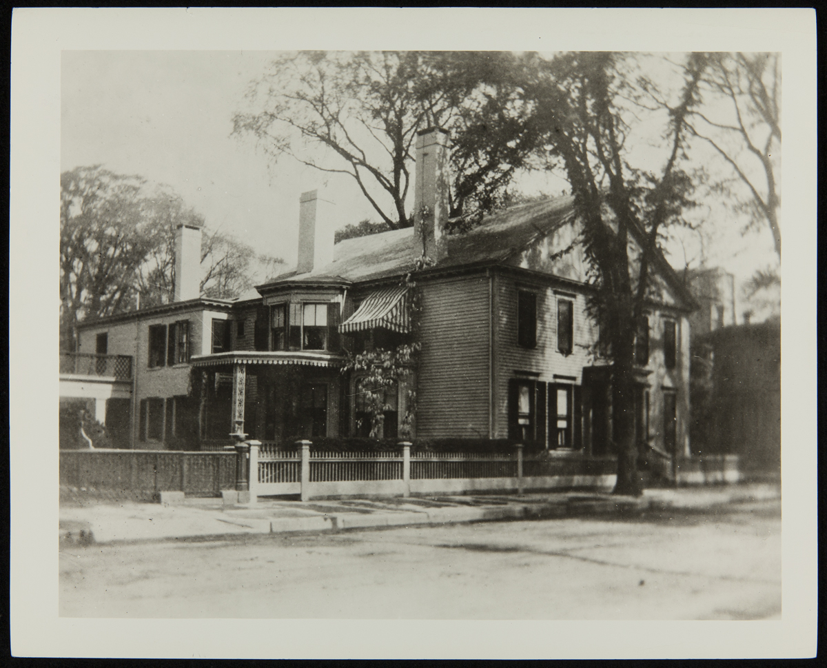 Large house on street with trees around it
