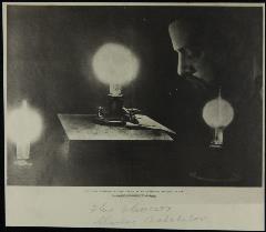 Portrait of Charles Batchelor, Man bows his head, eyes closed, among three illuminated light bulbs