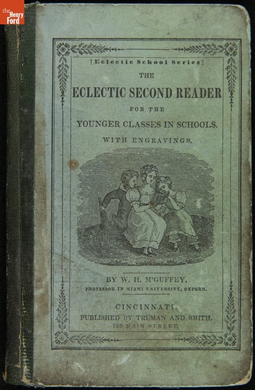 Textbook, Blue book cover with image of three people reading a book; also contains text