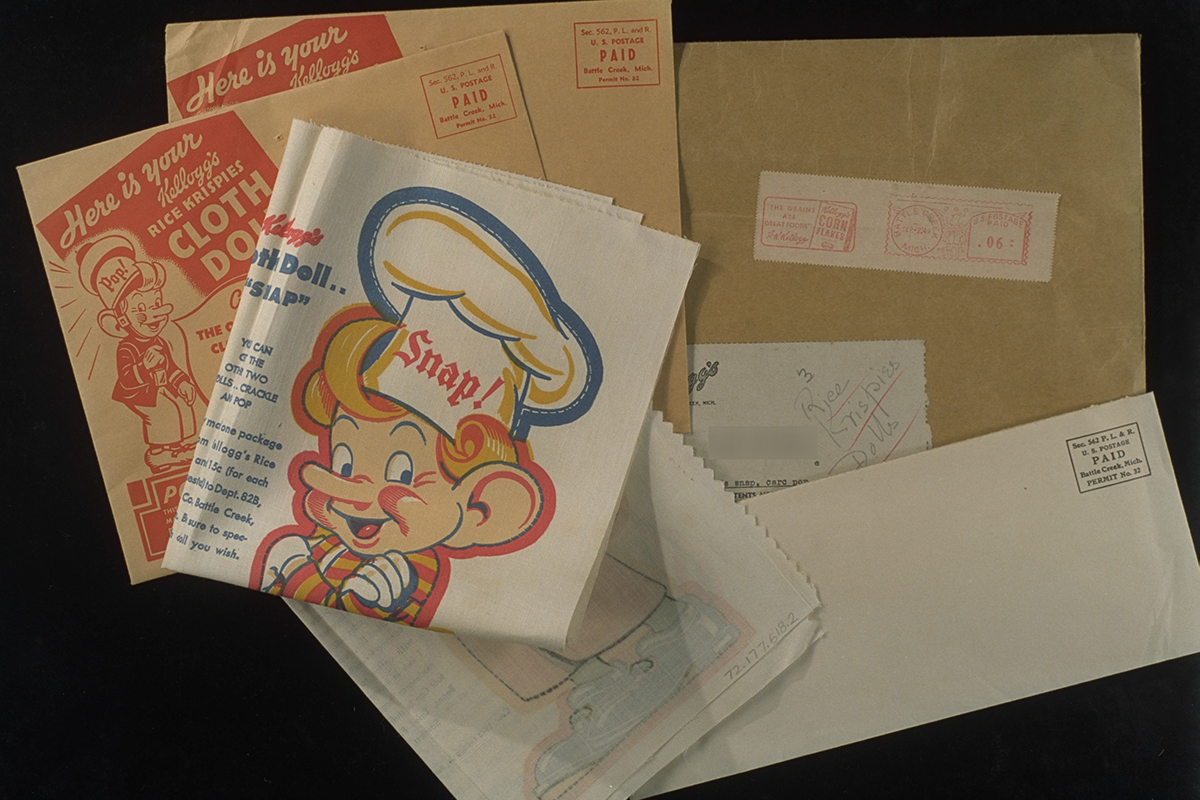 Doll Kit, 1949 Several mailing envelopes and folded fabric showing elf head and torso with “Snap!” printed on chef’s hat