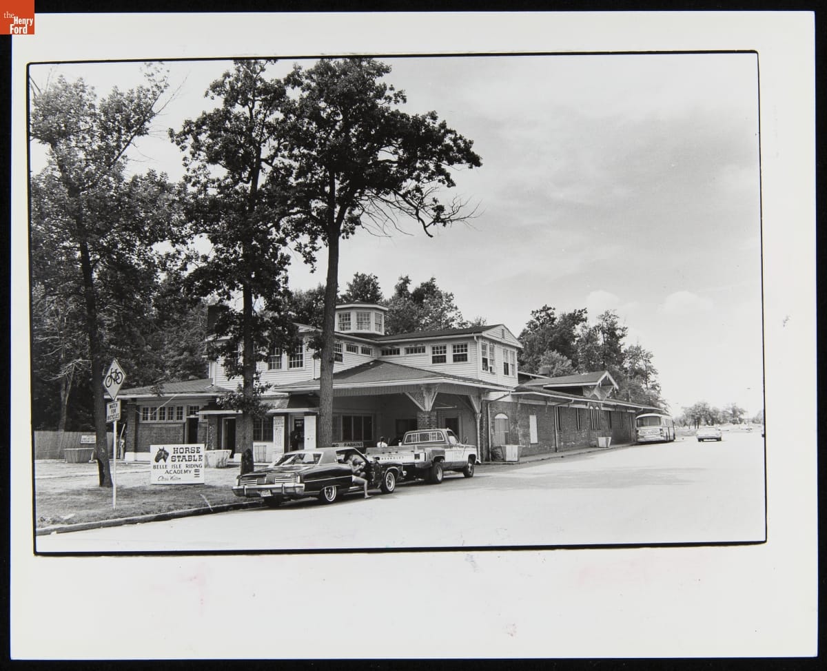 Elaborate two-story building with cars parked along street in front