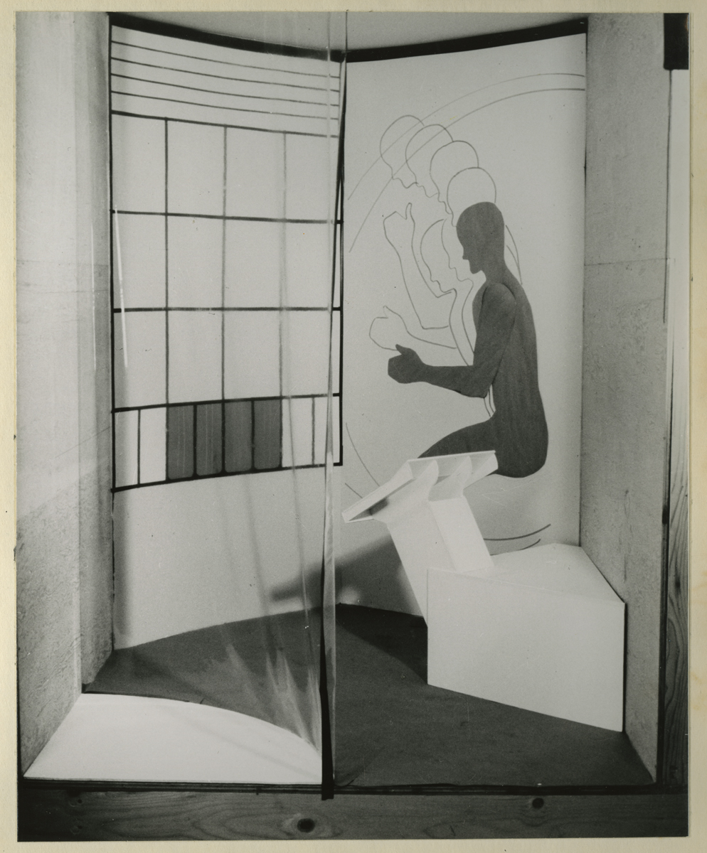 Report, Space with arc-shaped plastic enclosure, geometric pattern on walls, and silhouette on wall of figure squatting piece of equipment or furniture