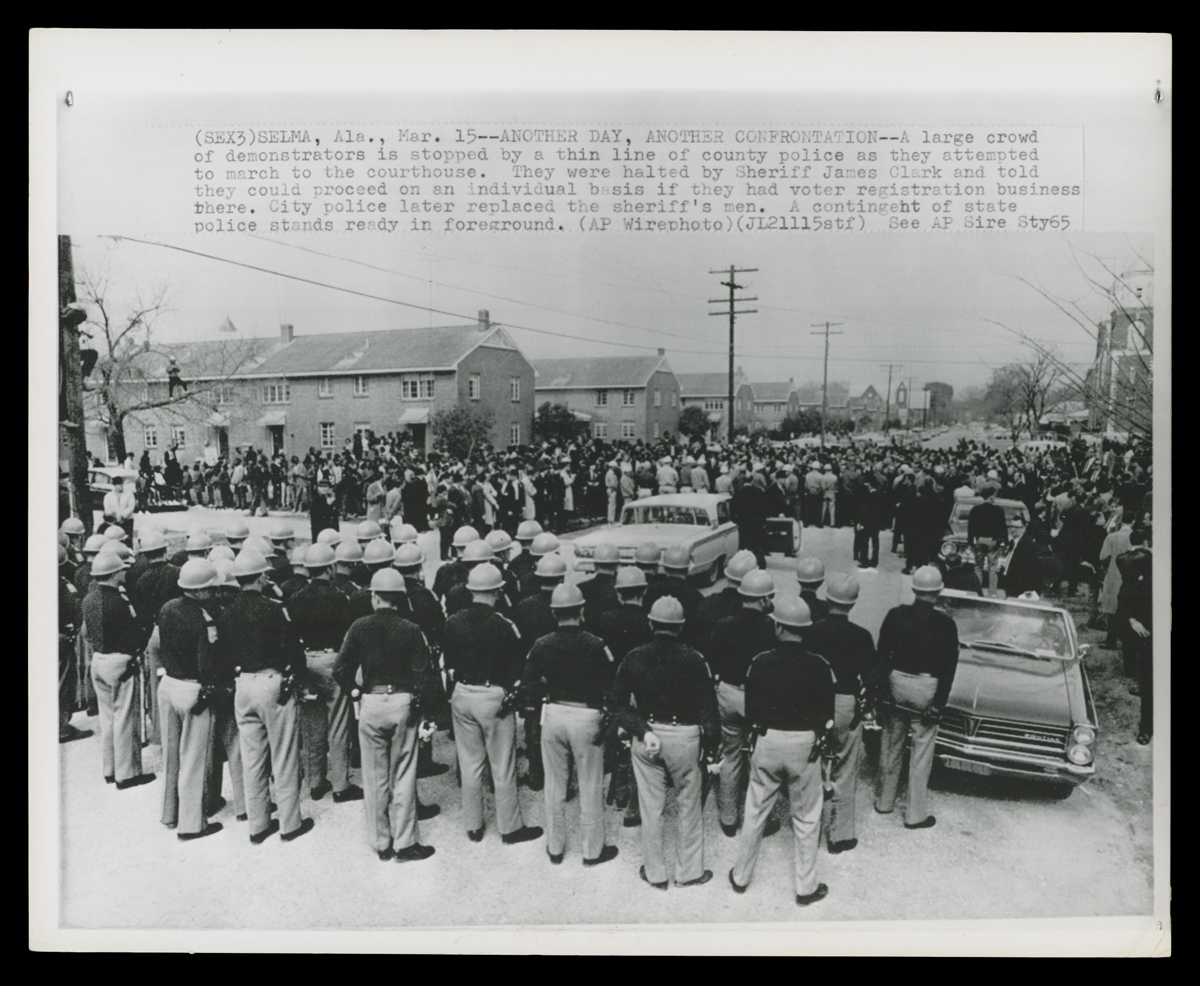 Police block a street in Selma, Alabama, on March 15, 1965, as voting rights demonstrators attempt to march to the Dallas County Courthouse. Brown Chapel AME Church is visible in the background.