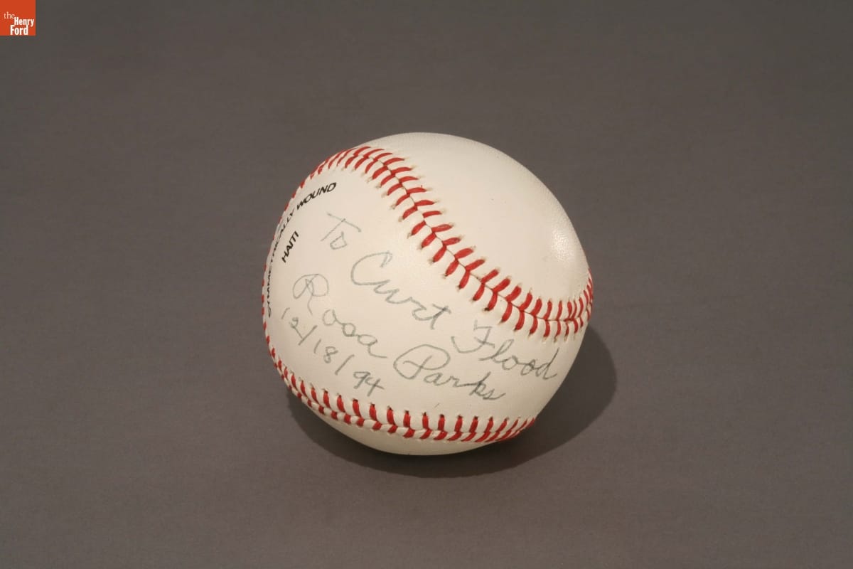 White baseball with red stitching and handwritten text
